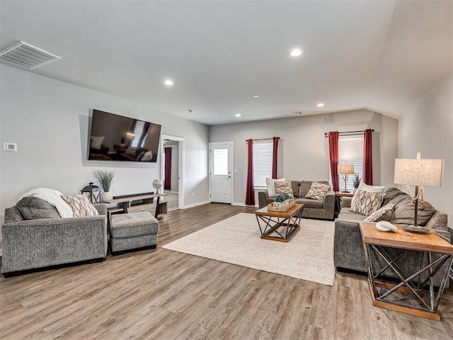 living room with baseboards, visible vents, wood finished floors, and recessed lighting