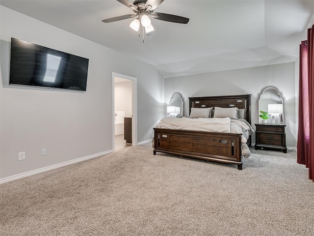 bedroom featuring lofted ceiling, ensuite bathroom, a ceiling fan, light carpet, and baseboards