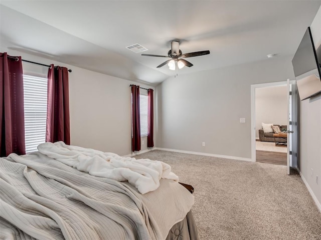 bedroom featuring light carpet, baseboards, visible vents, lofted ceiling, and ceiling fan