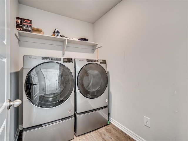 laundry area featuring laundry area, independent washer and dryer, wood finished floors, and baseboards