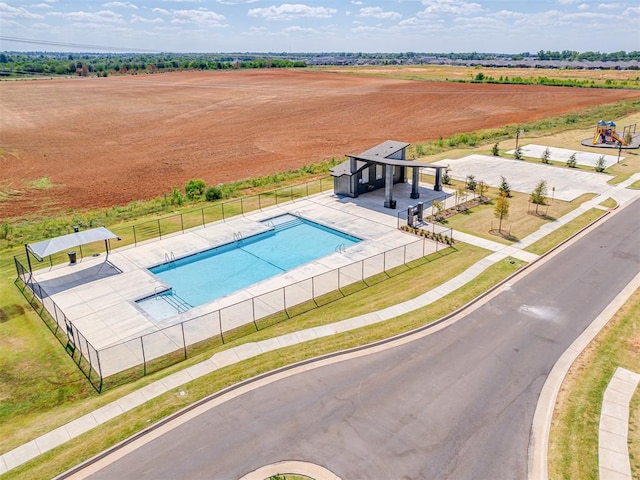 view of swimming pool featuring fence and a rural view