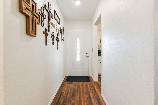 entryway with dark wood-type flooring and baseboards