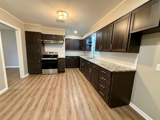 kitchen featuring visible vents, stainless steel range with electric cooktop, a sink, dark brown cabinets, and under cabinet range hood