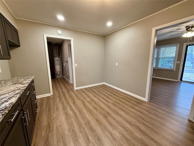 unfurnished dining area featuring light wood finished floors, water heater, and ornamental molding