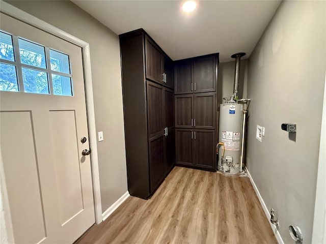 interior space featuring light wood-type flooring, baseboards, and gas water heater