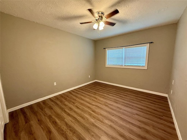 empty room featuring ceiling fan, a textured ceiling, baseboards, and wood finished floors