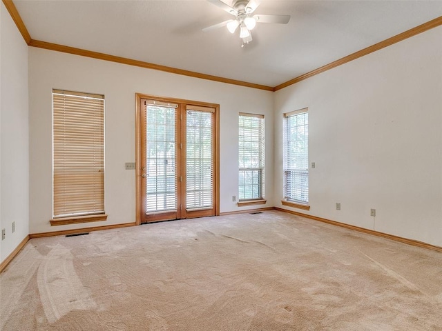 unfurnished room with carpet, visible vents, baseboards, and crown molding