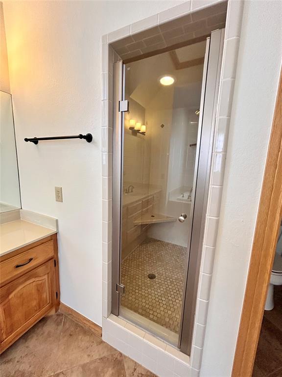 full bathroom with toilet, vanity, baseboards, tile patterned floors, and a stall shower