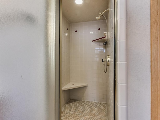 bathroom with a stall shower and a textured wall