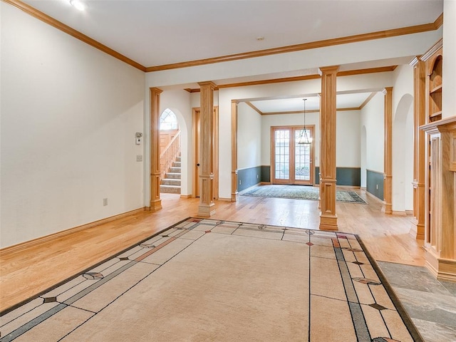 interior space featuring stairs, wood finished floors, and decorative columns