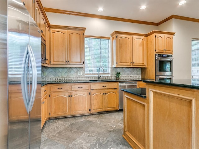 kitchen with crown molding, appliances with stainless steel finishes, a sink, and tasteful backsplash