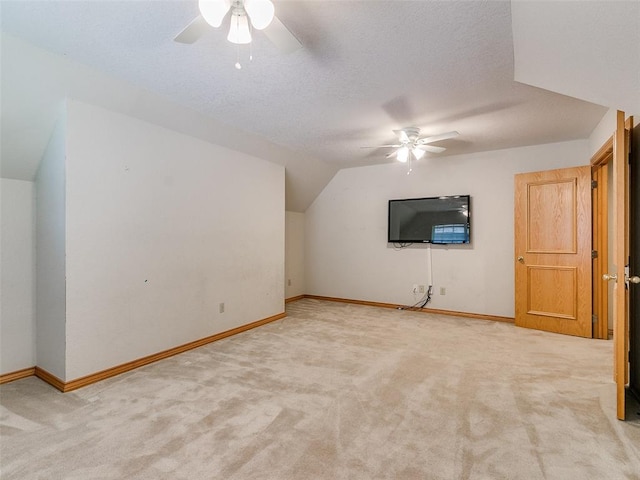 bonus room with lofted ceiling, light carpet, ceiling fan, and a textured ceiling