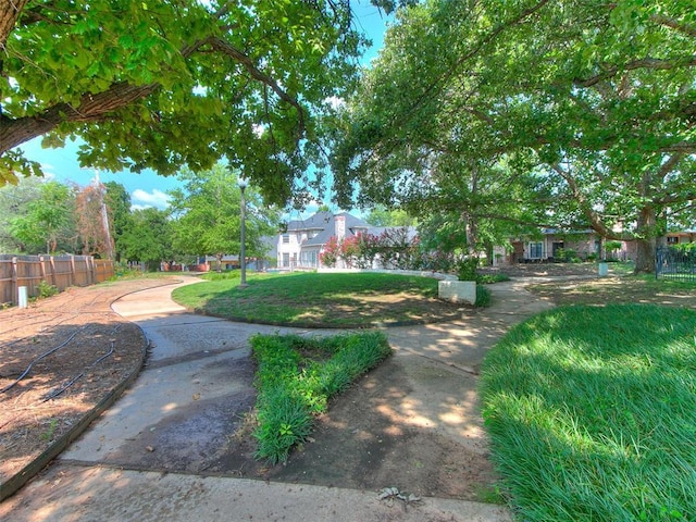 view of community with a yard and fence