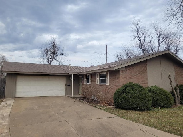 single story home featuring driveway, brick siding, and an attached garage