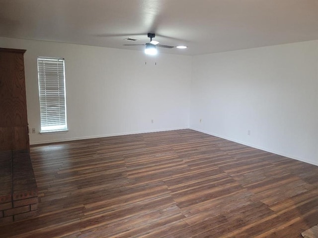 empty room featuring dark wood-type flooring, visible vents, and ceiling fan