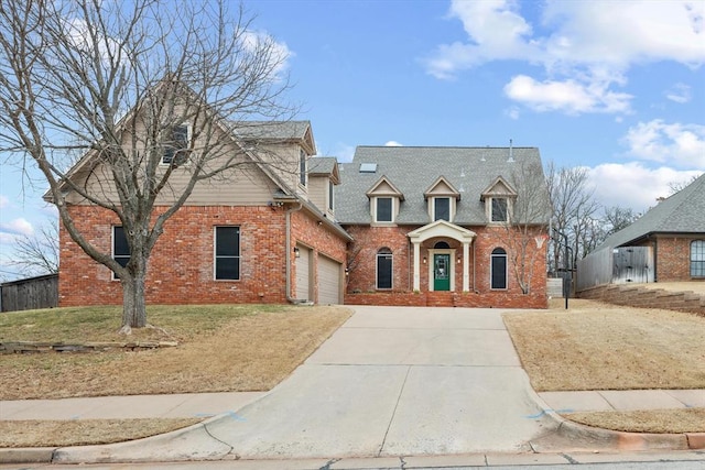 view of front of house featuring driveway, an attached garage, fence, and brick siding