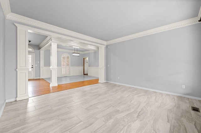 unfurnished living room with visible vents, light wood-style floors, wainscoting, ornate columns, and crown molding