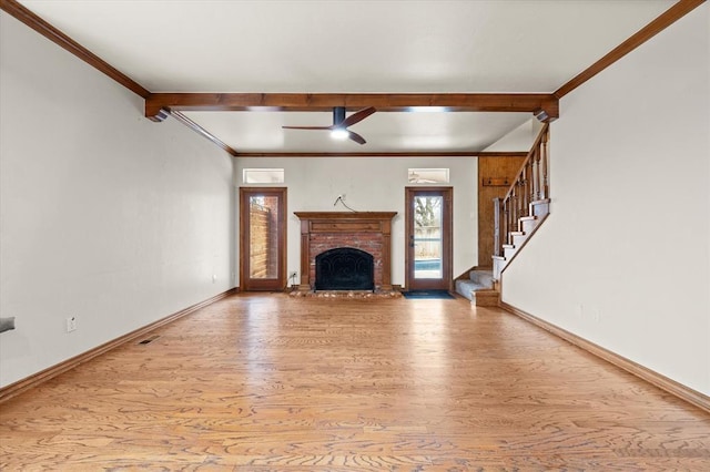 unfurnished living room with ornamental molding, stairway, wood finished floors, and baseboards