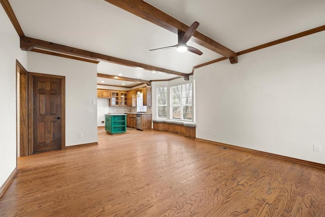 unfurnished living room featuring beamed ceiling, light wood-type flooring, and baseboards