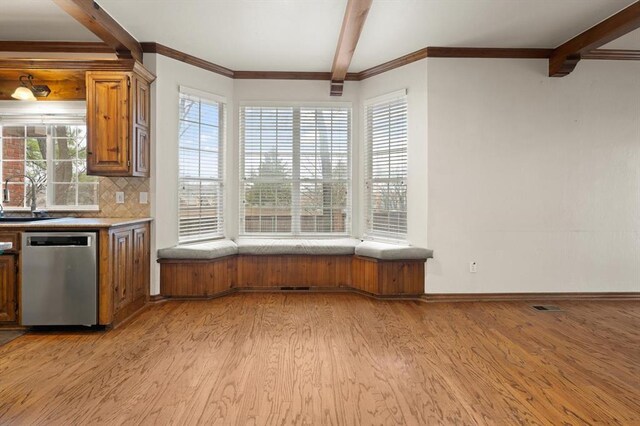 kitchen featuring light wood finished floors, tasteful backsplash, dishwasher, brown cabinets, and beam ceiling