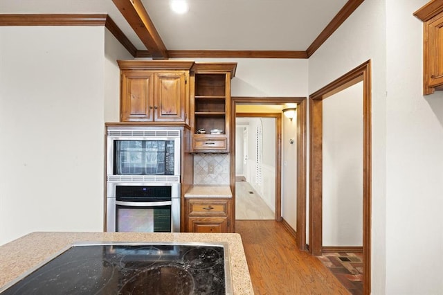 kitchen with light wood-style flooring, stainless steel appliances, ornamental molding, decorative backsplash, and brown cabinetry