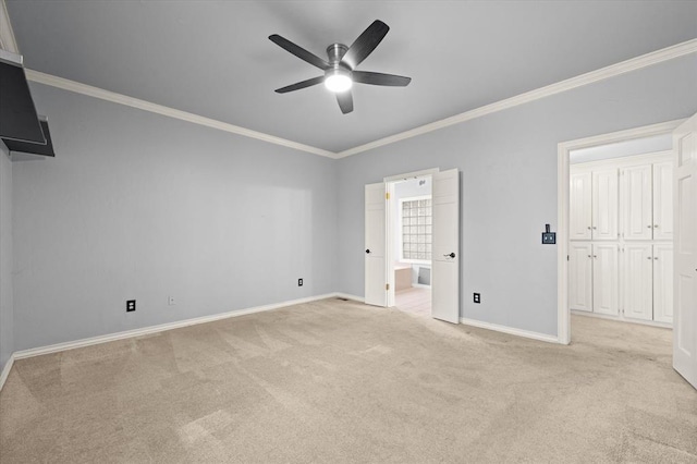 unfurnished bedroom featuring crown molding, light carpet, ceiling fan, ensuite bath, and baseboards