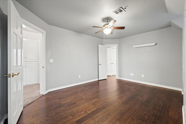 empty room with baseboards, ceiling fan, visible vents, and dark wood-style flooring