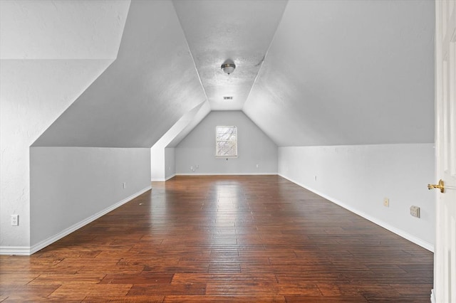 additional living space with baseboards, vaulted ceiling, and hardwood / wood-style floors