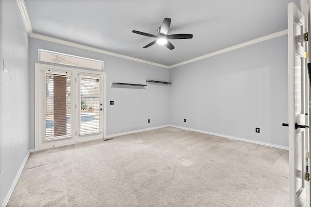 empty room featuring a ceiling fan, carpet, baseboards, and crown molding