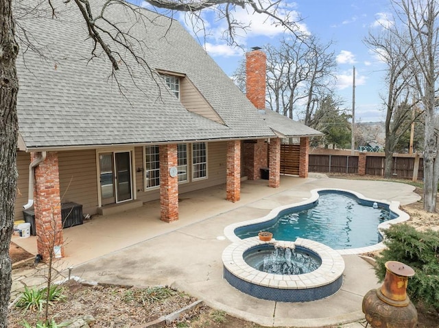 view of swimming pool featuring a patio area, a pool with connected hot tub, and fence