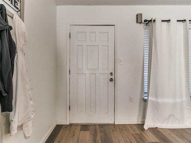 entrance foyer featuring baseboards and wood finished floors