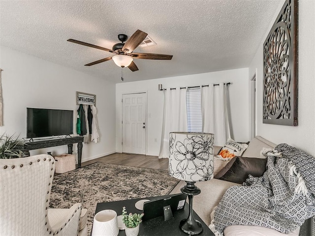 living room featuring a textured ceiling, a ceiling fan, and wood finished floors