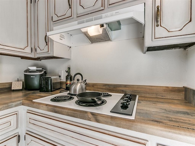 kitchen with white cooktop and under cabinet range hood