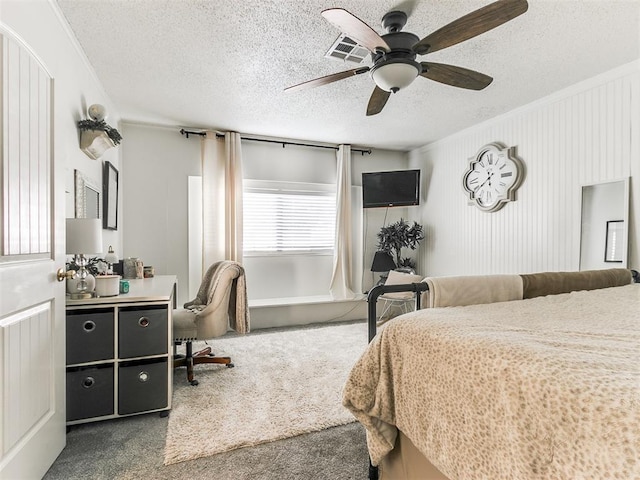 carpeted bedroom featuring a ceiling fan and a textured ceiling