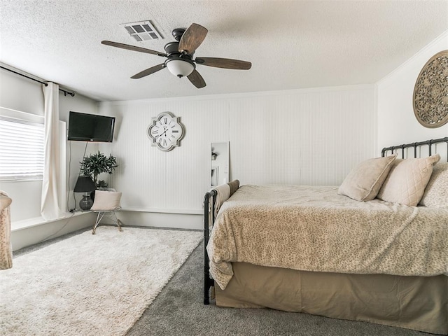 bedroom with a ceiling fan, visible vents, a textured ceiling, and carpet flooring