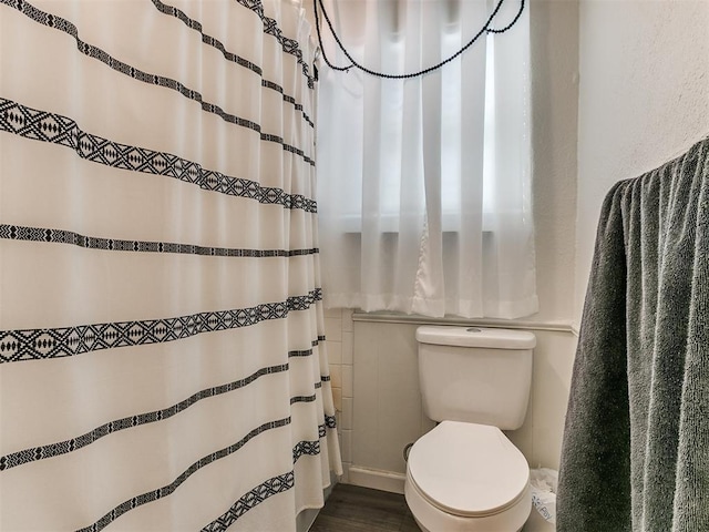 full bathroom featuring a shower with shower curtain, wood finished floors, and toilet