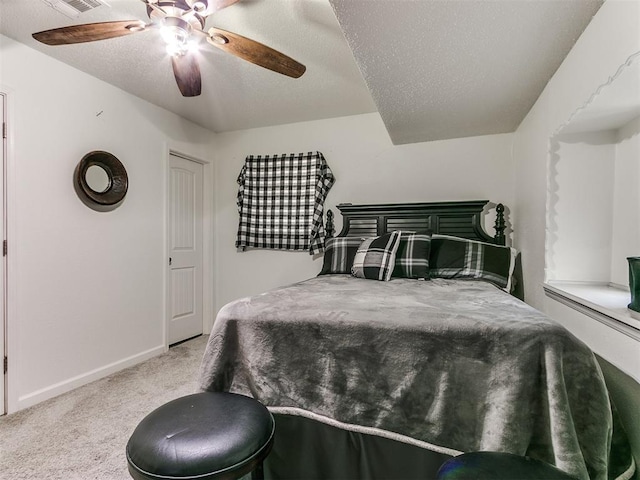 bedroom featuring carpet floors, visible vents, ceiling fan, a textured ceiling, and baseboards