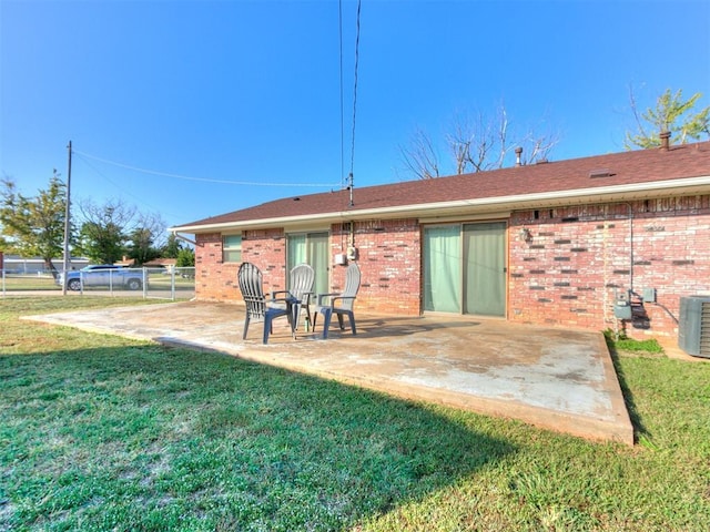 back of house with a patio area, fence, brick siding, and a yard