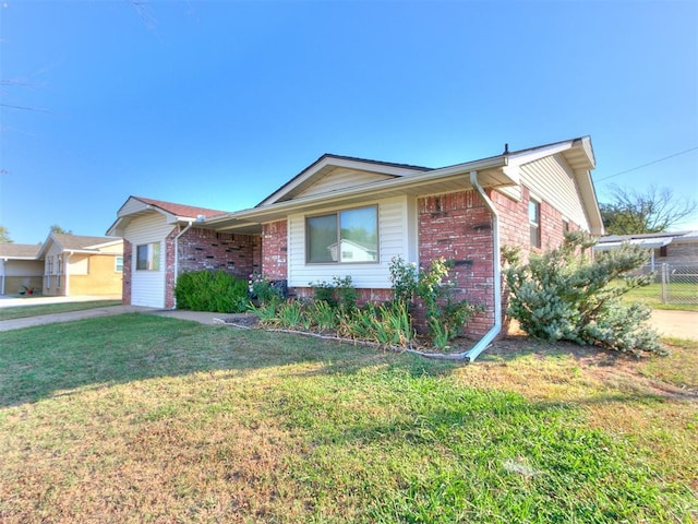 single story home with a front yard, fence, and brick siding