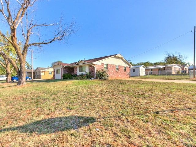 ranch-style house featuring brick siding, fence, and a front lawn