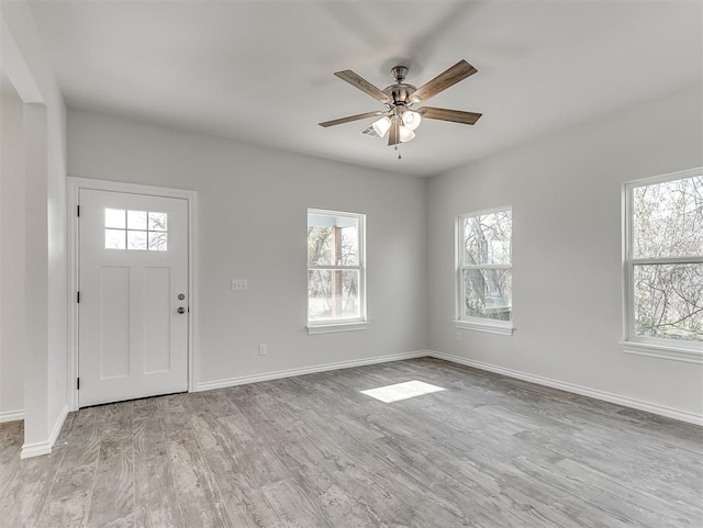 foyer entrance with a ceiling fan, baseboards, and wood finished floors