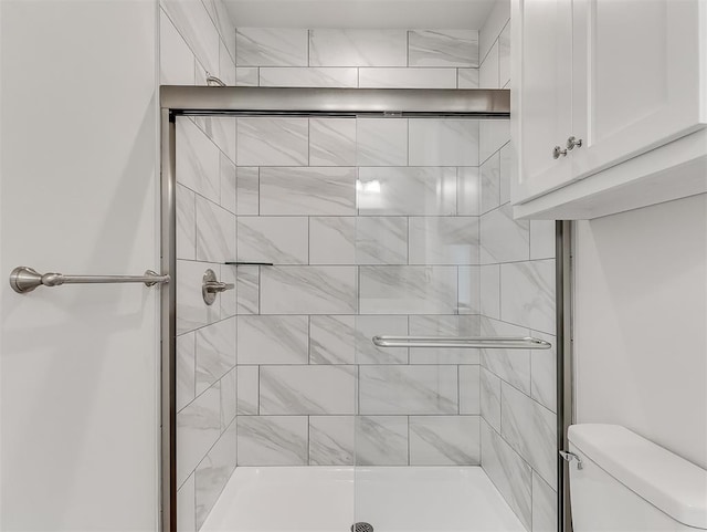 full bathroom with a stall shower and toilet