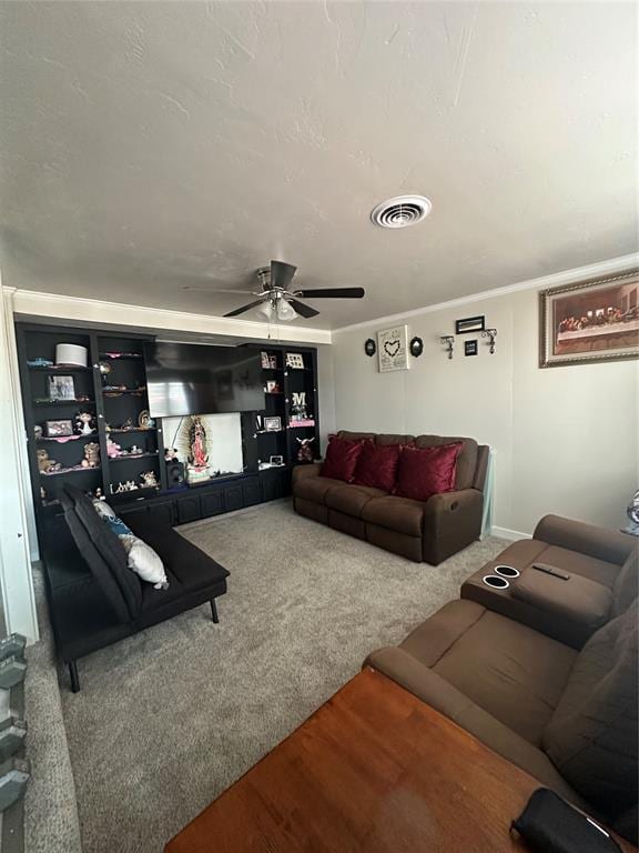 living area featuring carpet floors, ceiling fan, visible vents, and crown molding