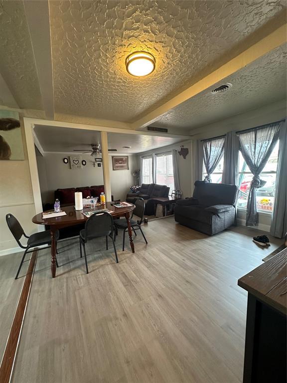 dining area with a textured ceiling, wood finished floors, and visible vents