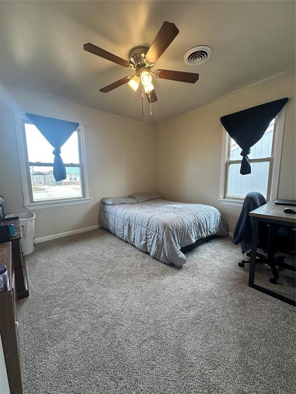 bedroom featuring ceiling fan, carpet floors, visible vents, and baseboards