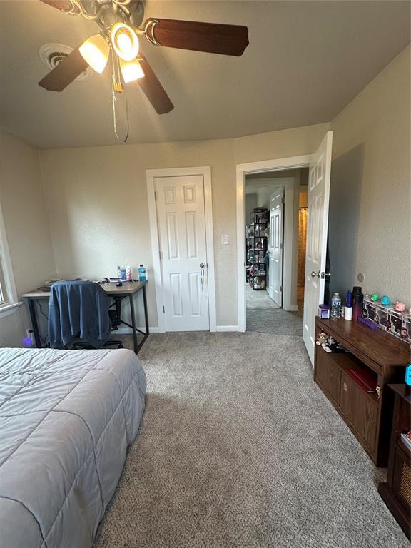 carpeted bedroom with a ceiling fan and baseboards