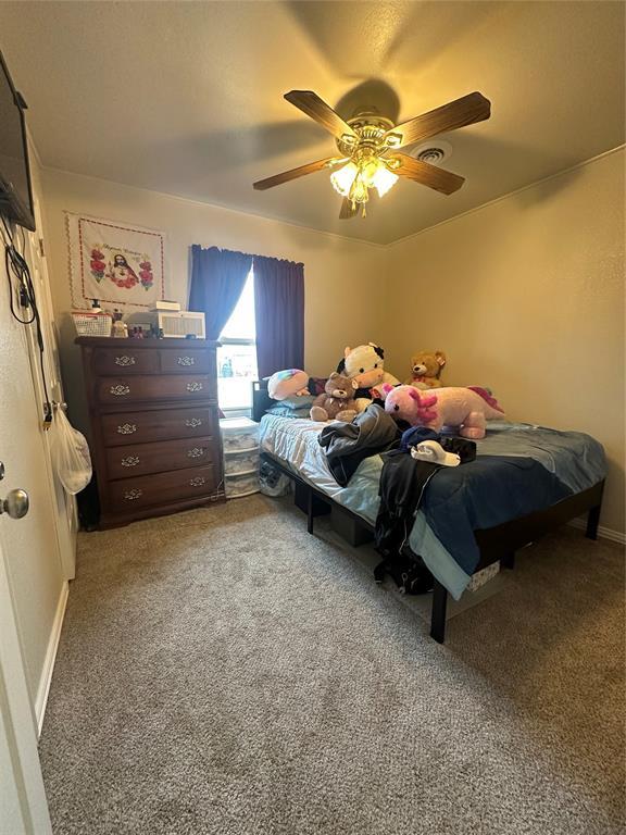 carpeted bedroom with baseboards and a ceiling fan