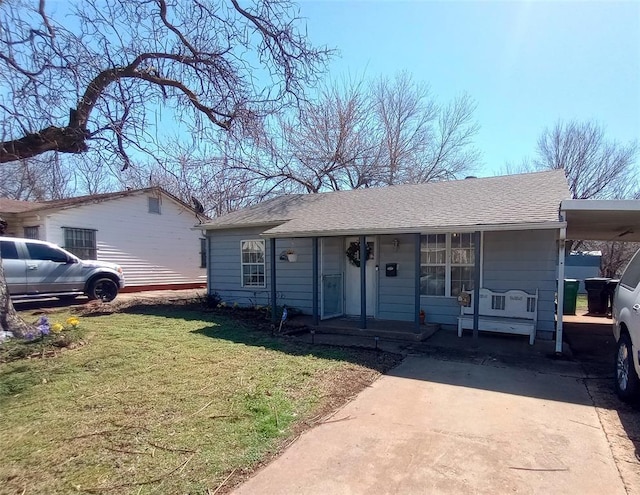 view of front of house with an attached carport, covered porch, a shingled roof, driveway, and a front yard