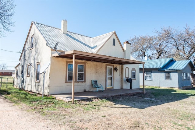 709 S Broadway, Geary, OK 73040 - view of front of property featuring metal roof, a patio, a chimney, and fence