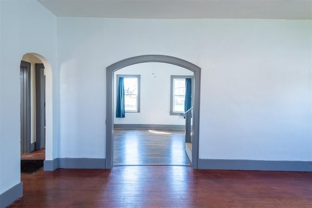 709 S Broadway, Geary, OK 73040 - unfurnished room with wood finished floors, arched walkways, and baseboards